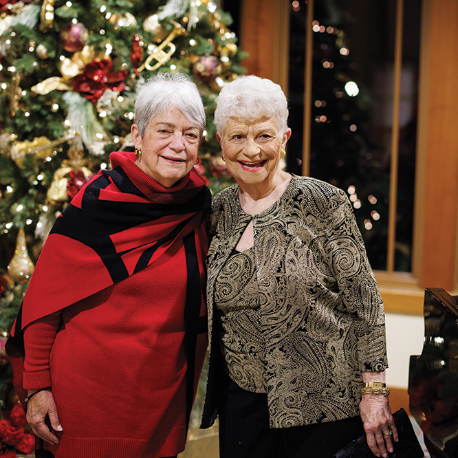 Two friends in front of the Christmas Tree